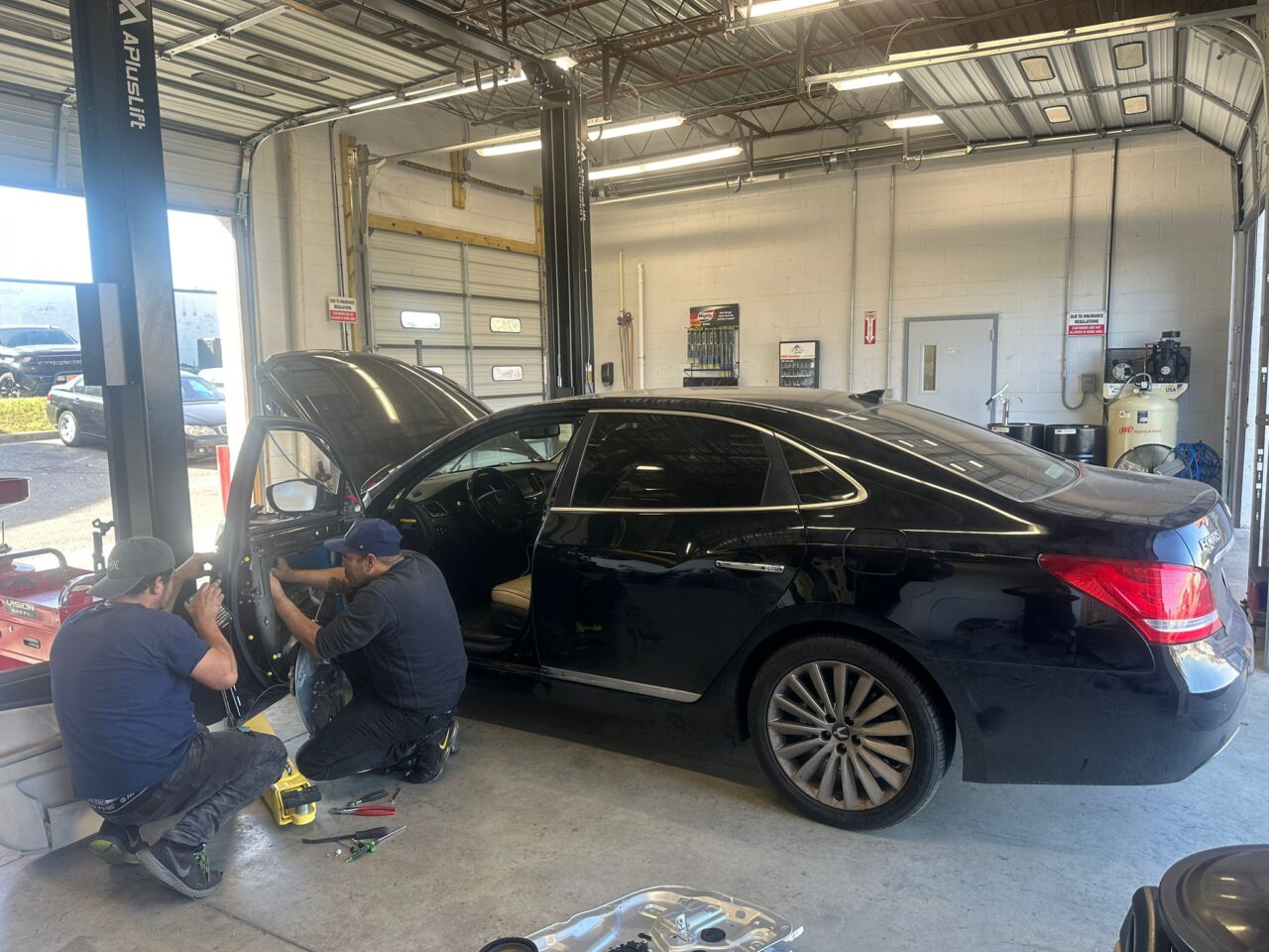 Wide interior view of the advanced collision repair shop showing vehicles undergoing restoration